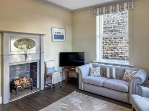 a living room with a couch and a fireplace at Bracken Hall House in Baildon