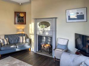 a living room with a couch and a fireplace at Bracken Hall House in Baildon