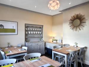 a restaurant with wooden tables and chairs and a mirror at Bracken Hall House in Baildon +38 photos