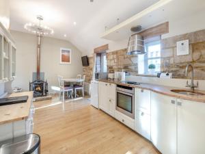 a kitchen with white cabinets and a stove top oven at Walnut Cottage - Ukc6632 in Pentney