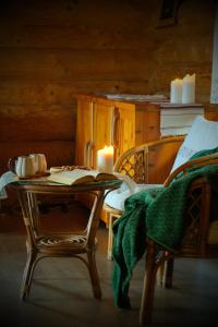 a room with a table with a candle and a bed at Wilcza Jama - domki, sauna in Lutowiska