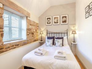 a bedroom with a bed with towels on it at Walnut Cottage - Ukc6632 in Pentney