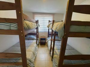 two bunk beds in a room with a window at Cabañas Cocodrilo Lodge in Molina