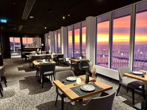 a restaurant with tables and chairs and large windows at RÜGEN-HOTEL mit Ostseeblick in Sassnitz