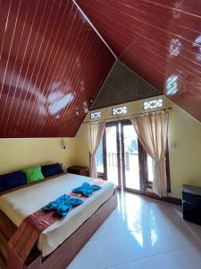 a bedroom with a large bed with a wooden ceiling at Meno Turtle BUNGALOWS in Gili Meno +31 photos