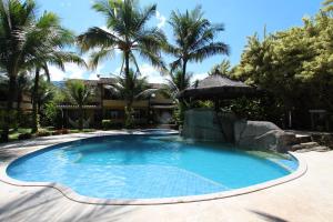 una piscina con palmeras y un edificio en Casa 32 Paraty, en Paraty