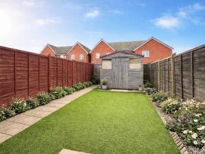 a garden with a fence and a small shed at Richborough House in Saint Peters