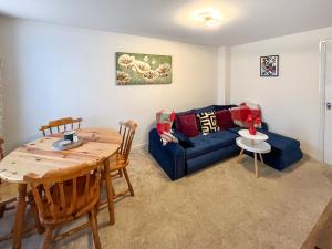 a living room with a blue couch and a table at Richborough House in Saint Peters