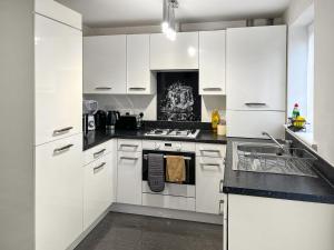 a kitchen with white cabinets and a stove top oven at Richborough House in Saint Peters +9 photos