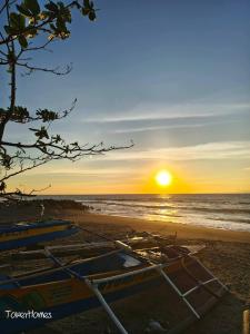 a group of boats on the beach at sunset at Duplex B- Seaside Haven Transient Inn at Caba, La Union in Caba