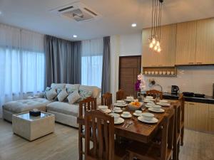 a kitchen and living room with a table and a couch at Vanesa Serenity Villa 1 in Ban Chong Phli
