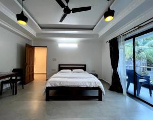 a bedroom with a bed and a table and a window at Morden AC 1bhk apartment near Cavelossim beach - Amor in Cavelossim
