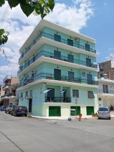 a blue and white building with cars parked in front of it at HELLAS PALACE ROOM PRIVATE in Sparta