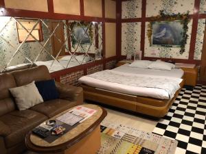 a living room with a bed and a couch at ホテルNO name in Tōgane