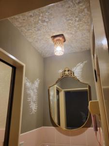 a bathroom with a mirror and a chandelier at ホテルNO name in Tōgane