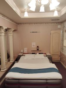 a large bed in a room with columns at ホテルNO name in Tōgane