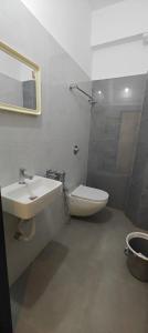 a bathroom with a sink and a toilet and a mirror at Vijaya Inn in Visakhapatnam