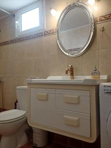 a bathroom with a sink and a toilet and a mirror at Spiti Lou in Nótos +34 photos