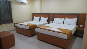 two beds in a hotel room at Vijaya Inn in Visakhapatnam +5 photos