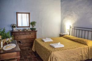 a bedroom with a bed and a table and a mirror at Locanda Il Pino in San Gimignano