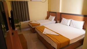 a bedroom with two beds and a television in it at Vijaya Inn in Visakhapatnam