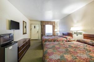 a hotel room with two beds and a flat screen tv at Rodeway Inn Magic Mountain Area in Castaic +18 photos