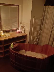 a bath tub in a bathroom with a sink and a mirror at Faschingalm Loft in Lienz +9 photos