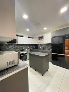 a large kitchen with black and white appliances at Villa san maria in Bakuriani