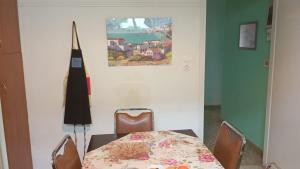 a dining room with a table and chairs and a picture on the wall at Hellas Palace ROOMS LOFT in Sparta