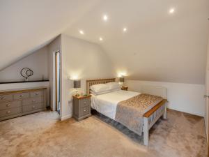 a white bedroom with a bed and a dresser at The Aran - Uk51067 in Frongoch