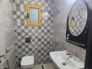 a bathroom with a sink and a toilet and a mirror at Jasmin Prestige Duplex - Hammamet in Hammamet +41 photos