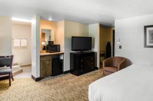 a hotel room with a bed and a flat screen tv at Comfort Inn & Suites Ashland in Ashland
