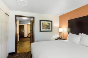 a hotel room with a large bed and a hallway at Comfort Inn & Suites Ashland in Ashland +21 photos