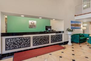 a lobby with a reception desk and a green wall at Quality Inn Enola - Harrisburg in Harrisburg