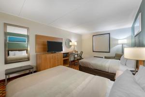a hotel room with two beds and a flat screen tv at Quality Inn Enola - Harrisburg in Harrisburg