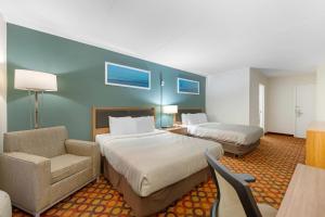 a hotel room with two beds and a chair at Quality Inn Enola - Harrisburg in Harrisburg +35 photos