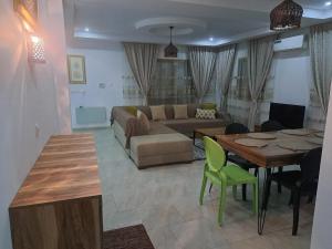 a living room with a couch and a table at Jasmin Prestige Duplex - Hammamet in Hammamet