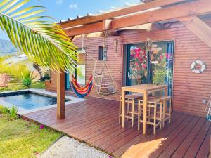 a wooden deck with a table and chairs and a hammock at Anaélodge in Le Tampon