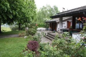 a house with a garden and a table and chairs at Villa San Giorgio in Pellio Superiore
