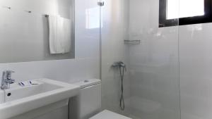 a white bathroom with a shower and a sink at FBC Fortuny Resort - Adults Only in Maspalomas