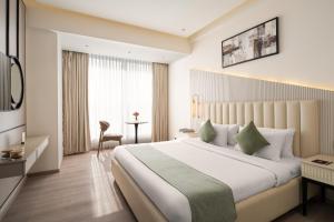 a hotel room with a large bed and a desk at Foxtrail Sector 60 - AM Hotel Kollection, Gurgaon in Gurgaon +30 photos