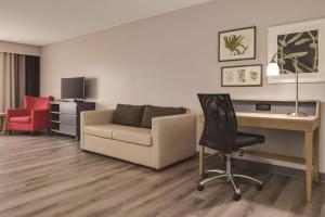 a living room with a couch and a desk and a chair at Country Inn & Suites by Radisson, Waterloo, IA in Waterloo