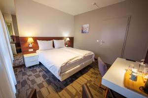 a hotel room with a bed and a table at Hotel Saint-Hubert in Hambach