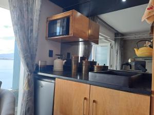 a kitchen with a sink and a microwave at Boutique Inn - Quintessence in Gordonʼs Bay