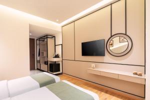 a bedroom with two beds and a mirror at Foxtrail Sector 60 - AM Hotel Kollection, Gurgaon in Gurgaon