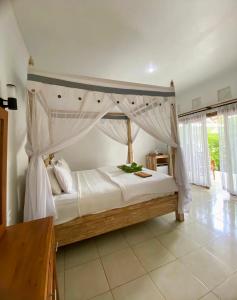 a bedroom with a canopy bed in a room at Sama Sama Amed in Amed