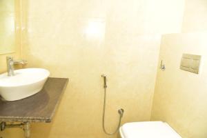 a bathroom with a sink and a toilet at Hotel Jaipur Shertone in Jaipur