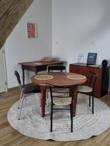 a wooden table and chairs on a rug in a room at Zen suite Moulin de Vilaine in Châteauroux +40 photos