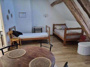 a living room with two beds and a table at Zen suite Moulin de Vilaine in Châteauroux