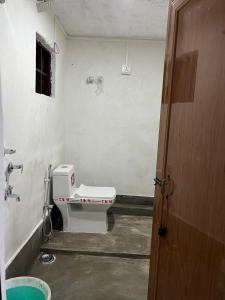a bathroom with a toilet in the corner of a room at Pushpa Nilayam in Khaprail +31 photos
